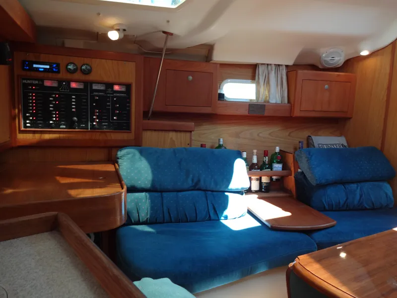 Slide: The Image of Interior of 2001 Hunter 380 sailboat with blue seating and wooden cabinetry. - 33