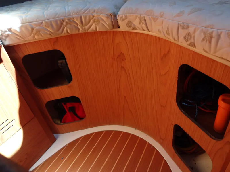 Slide: The Image of Interior of 2001 Hunter 380 sailboat with wooden storage compartments and cushioned seating. - 40