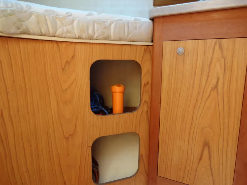 Slide: The Image of Wooden interior storage on 2001 Hunter 380 boat with orange flashlight. - 41