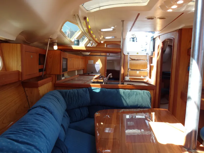 Slide: The Image of Interior of 2001 Hunter 380 sailboat with wood finish and blue seating. - 44