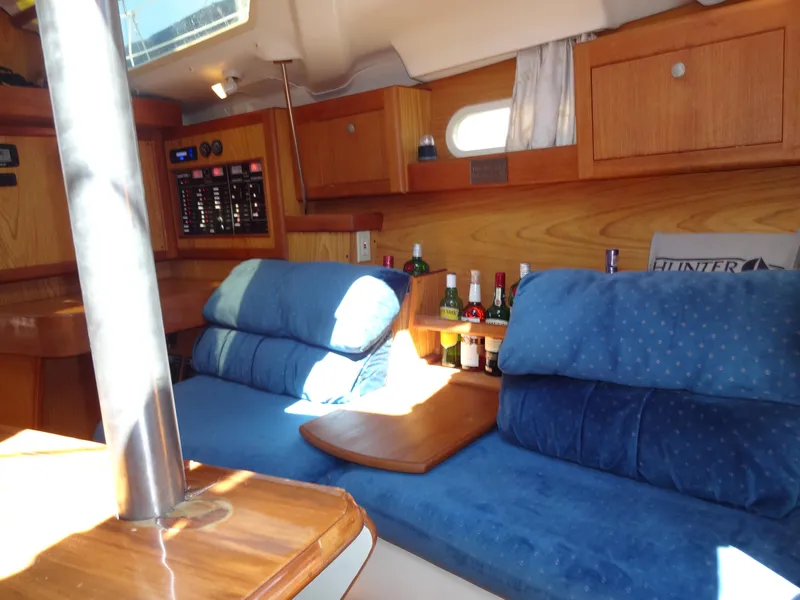 Slide: The Image of Interior of 2001 Hunter 380 sailboat with blue seating and wooden cabinetry. - 47