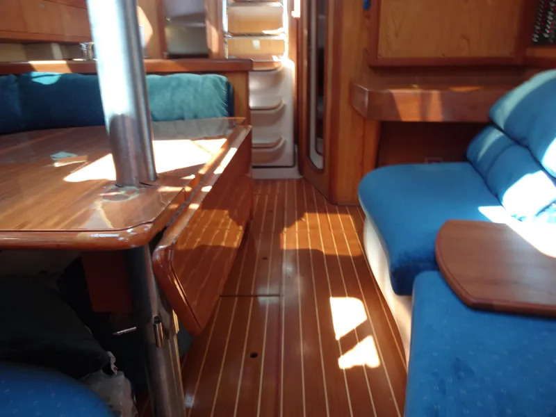 Slide: The Image of Interior of 2001 Hunter 380 sailboat with wooden furnishings and blue seating. - 48