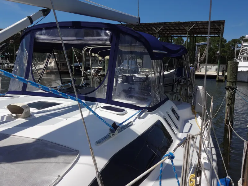 Slide: The Image of 2001 Hunter 380 sailboat docked at marina, featuring blue canopy and sleek design. - 6