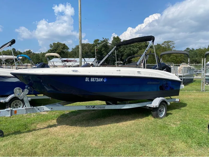 Slide: The Image of 2020 Bayliner Element E18 boat on trailer, parked on grass under a blue sky. - 1