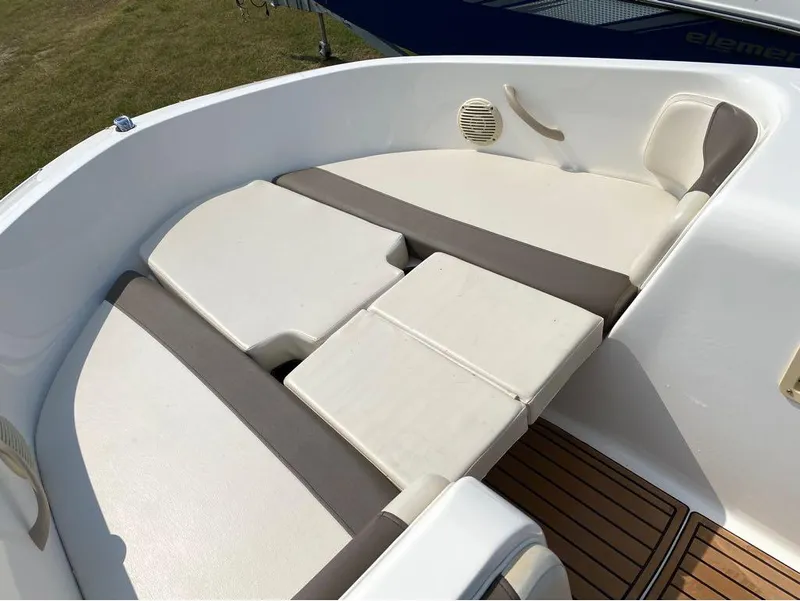 Slide: The Image of 2020 Bayliner Element E18 boat interior with cushioned seating and wood-style flooring. - 2