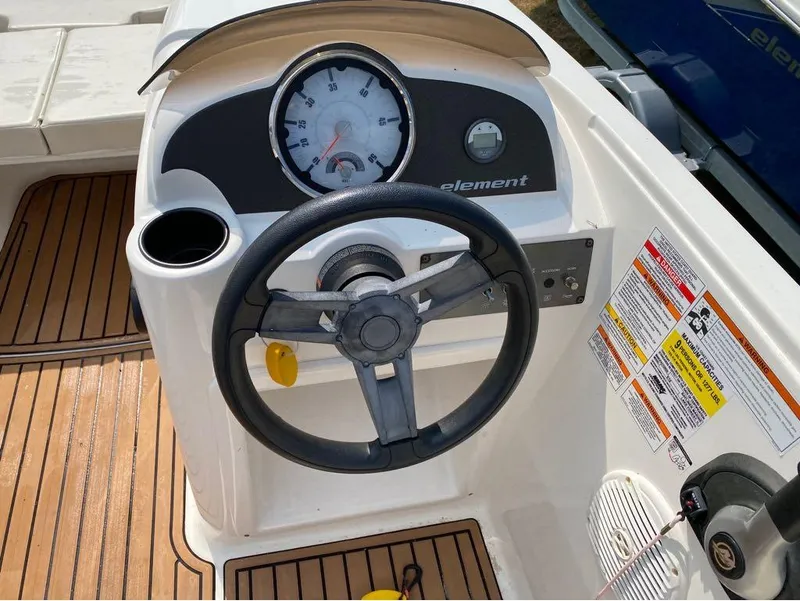 Slide: The Image of 2020 Bayliner Element E18 boat dashboard with steering wheel and gauges. - 3