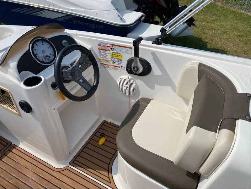 Slide: The Image of 2020 Bayliner Element E18 boat interior with steering wheel and seating. - 5