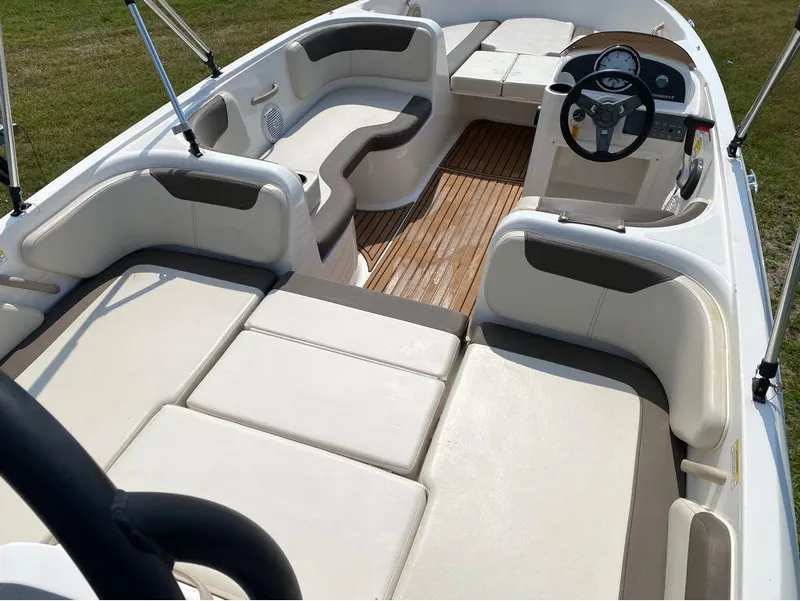 Slide: The Image of 2020 Bayliner Element E18 boat interior with spacious seating and modern dashboard. - 8