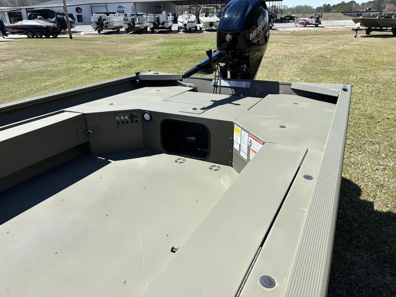 Slide: The Image of 2025 Tracker Grizzly 1654 T SportMan boat with Mercury engine, parked outdoors. - 13