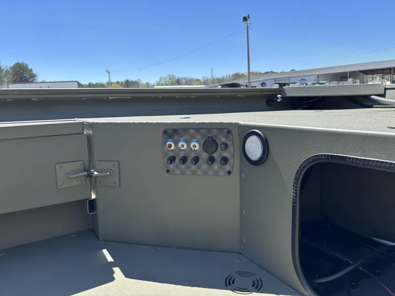 Slide: The Image of 2025 Tracker Grizzly 1654 T SportMan boat interior with control panel and storage compartment. - 14