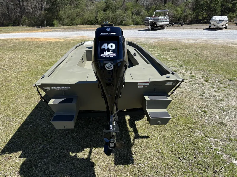 Slide: The Image of 2025 Tracker Grizzly 1654 T SportMan boat with Mercury 40 HP engine, parked on grass. - 4