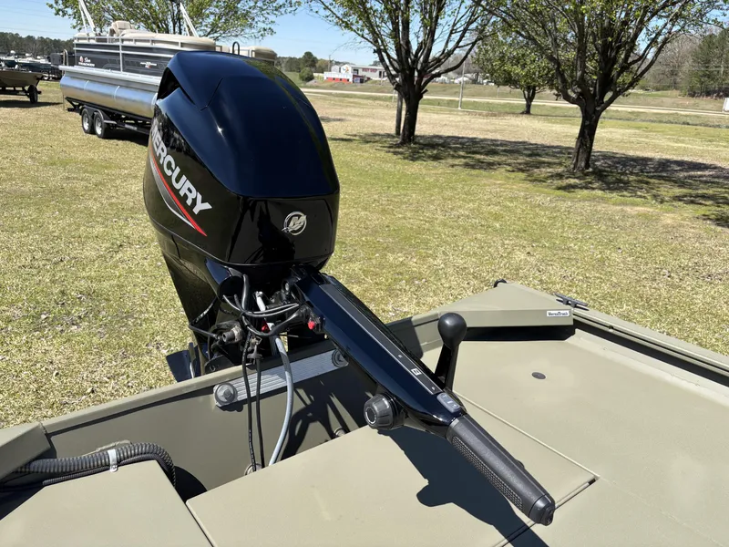 Slide: The Image of 2025 Tracker Grizzly 1654 T SportMan boat with Mercury outboard motor in a grassy area. - 5