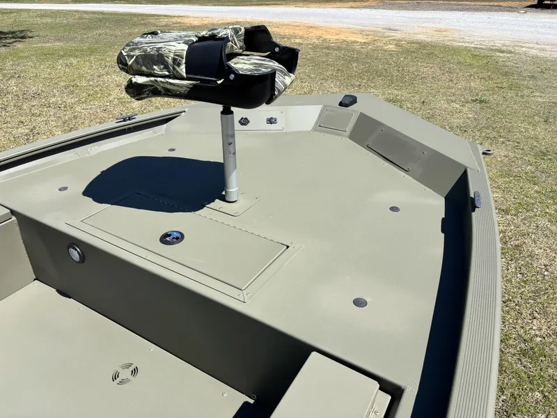 Slide: The Image of 2025 Tracker Grizzly 1654 T SportMan boat deck with camo seat, parked on grass. - 7