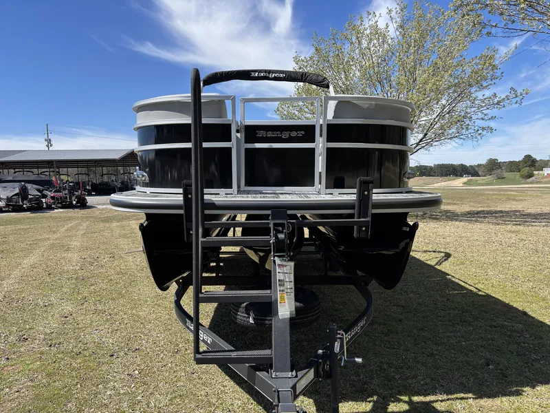 Slide: The Image of 2024 Ranger 223C pontoon boat on trailer, parked on grassy area under clear sky. - 10