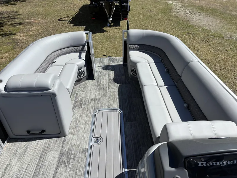 Slide: The Image of 2024 Ranger 223C pontoon boat interior with gray seating and wood-style flooring. - 13