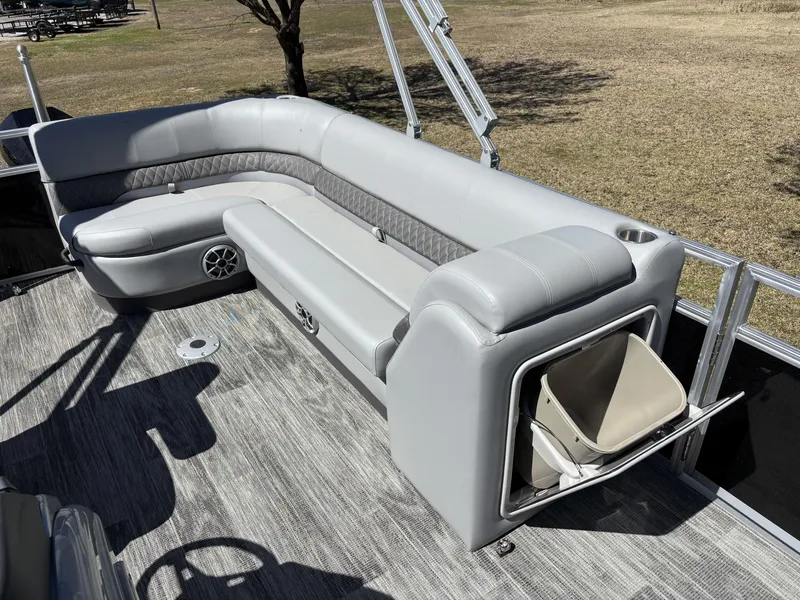 Slide: The Image of 2024 Ranger 223C boat interior with gray seating, storage compartment, and cup holder on deck. - 5