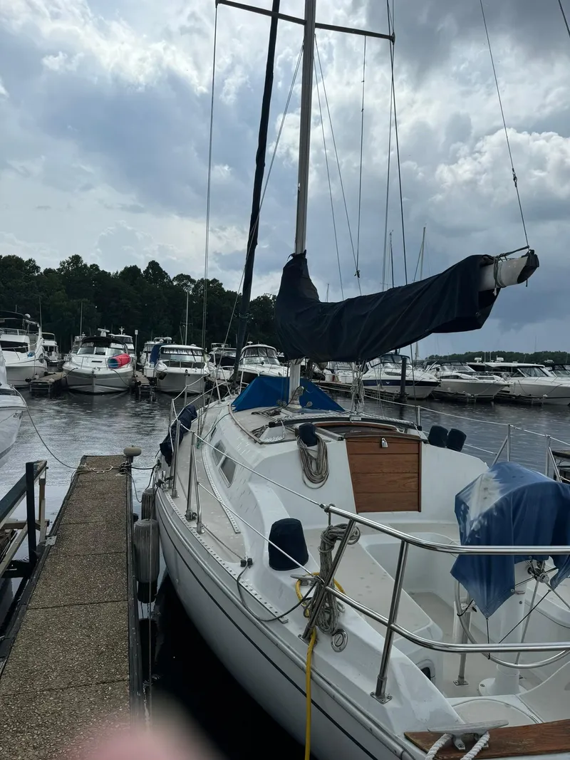 The Image of 1987 Ericson 35-3 sailboat docked at marina under cloudy sky. - 0