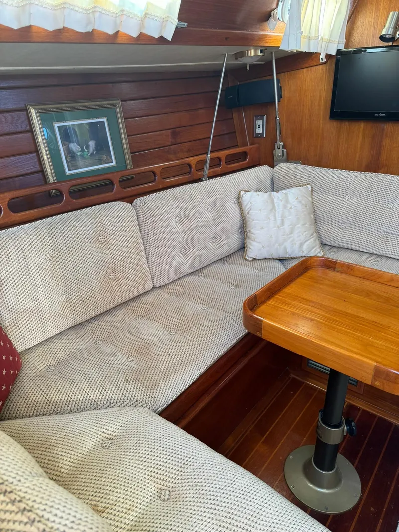 Slide: The Image of Cozy interior of 1987 Ericson 35-3 sailboat with cushioned seating and wooden table. - 15