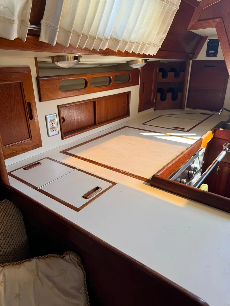 Slide: The Image of 1987 Ericson 35-3 yacht interior kitchen with wooden cabinets and white countertops. - 18