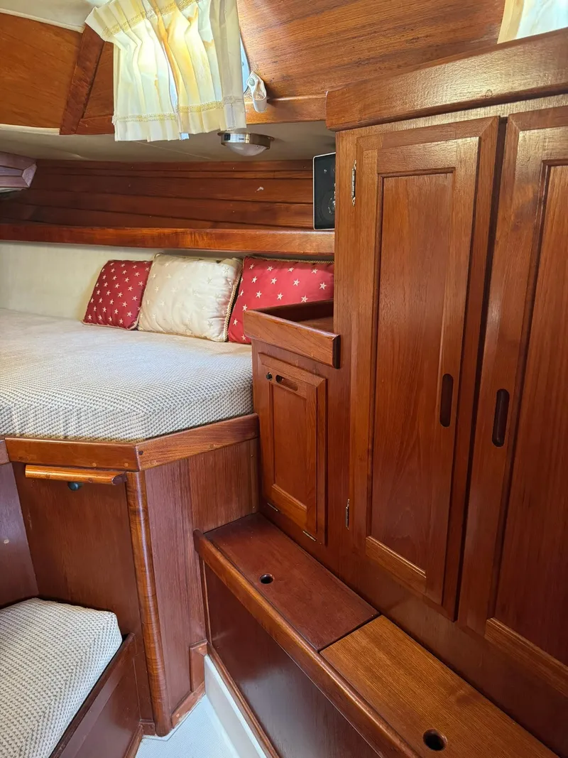 Slide: The Image of 1987 Ericson 35-3 sailboat interior with wooden cabinetry and cozy sleeping area. - 23