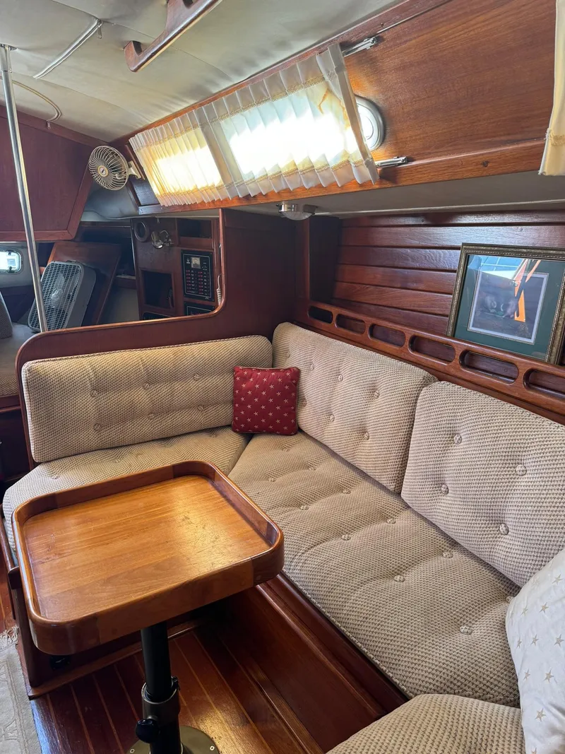 Slide: The Image of Cozy interior of 1987 Ericson 35-3 sailboat with cushioned seating and wooden table. - 25