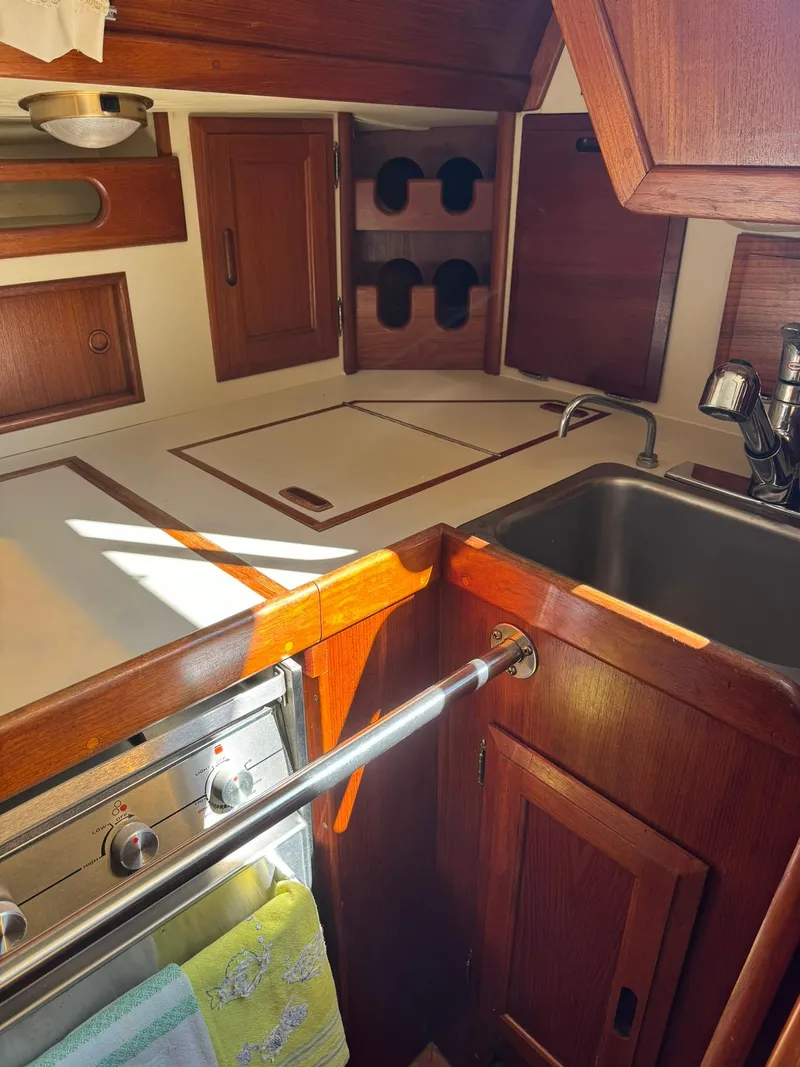 Slide: The Image of 1987 Ericson 35-3 sailboat kitchen with wooden cabinets and stainless steel sink. - 26