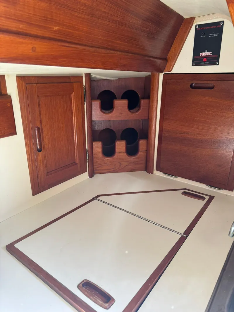 Slide: The Image of Interior of 1987 Ericson 35-3 sailboat with wooden cabinetry and storage compartments. - 27