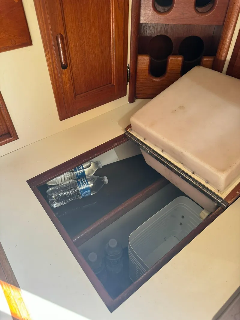 Slide: The Image of Storage compartment in 1987 Ericson 35-3 sailboat with water bottles and containers. - 29