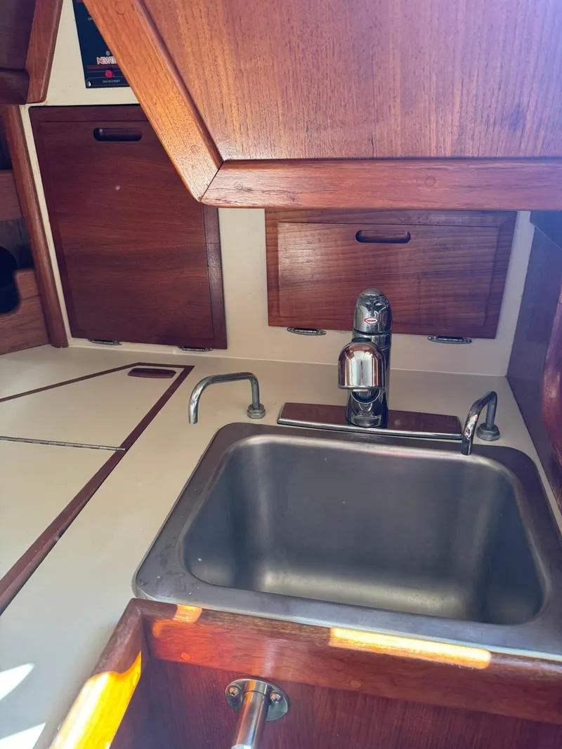 Slide: The Image of 1987 Ericson 35-3 yacht kitchen sink with wooden cabinetry. - 30