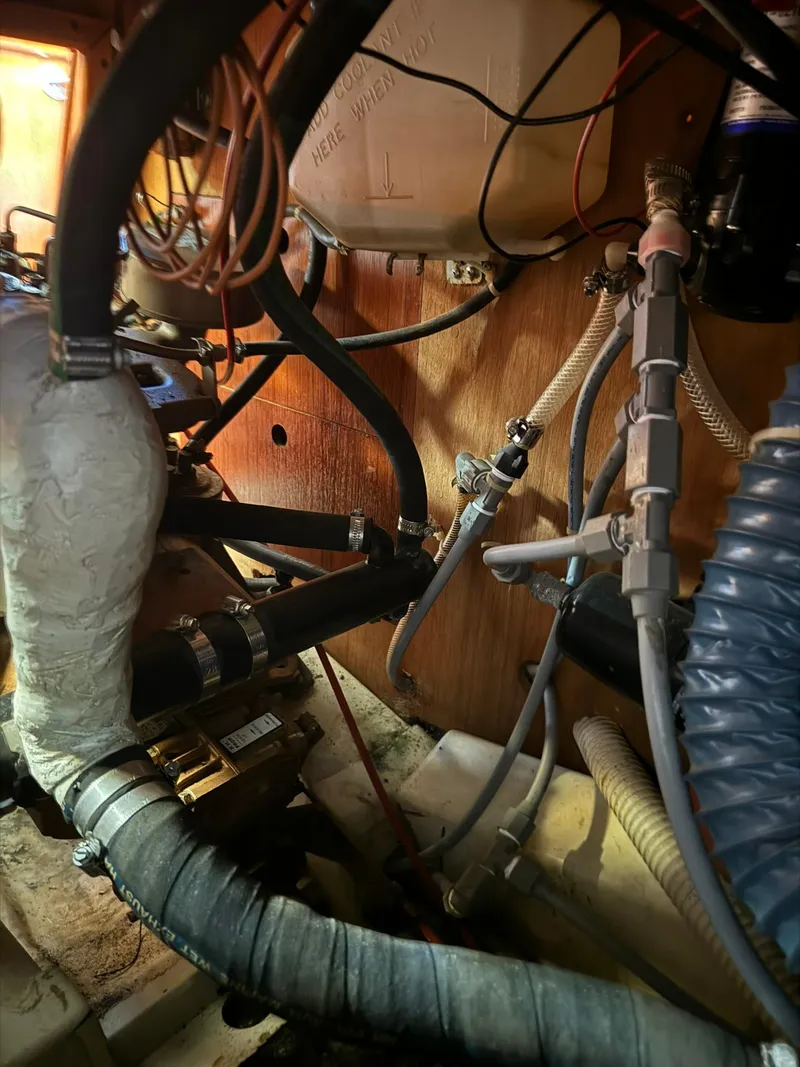 Slide: The Image of Engine compartment of a 1987 Ericson 35-3 sailboat with hoses and wiring. - 33