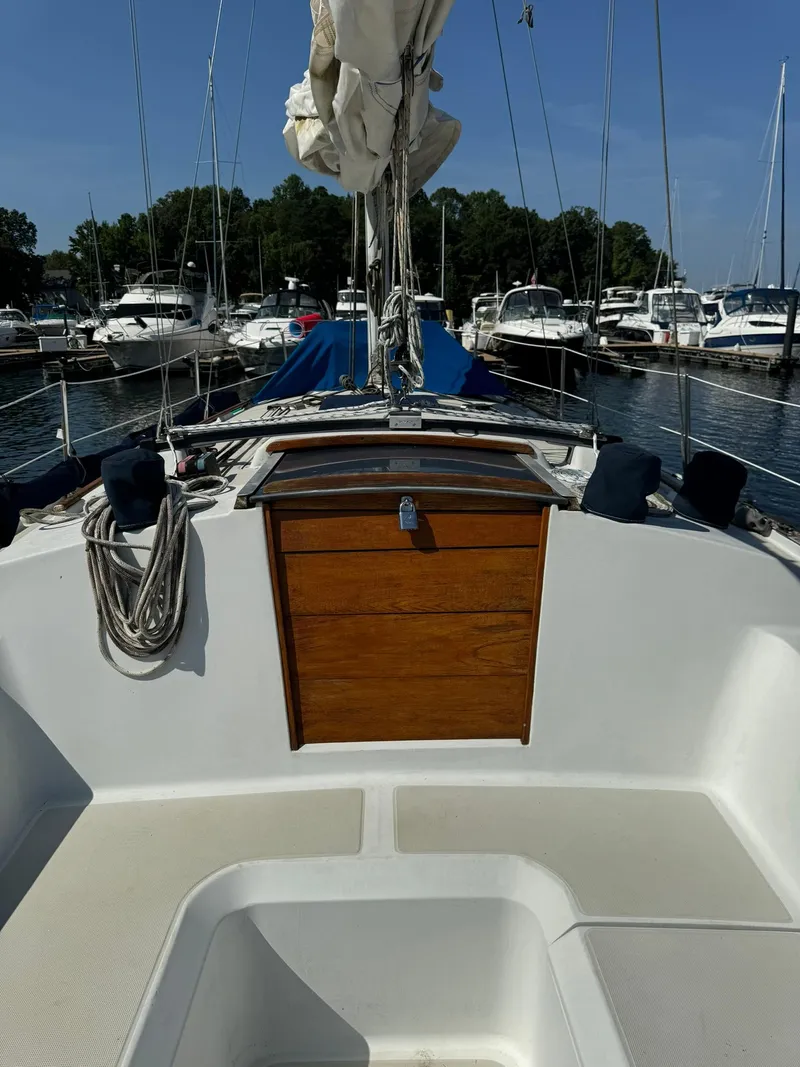 Slide: The Image of 1987 Ericson 35-3 sailboat docked at marina, featuring wooden hatch and rigging. - 5