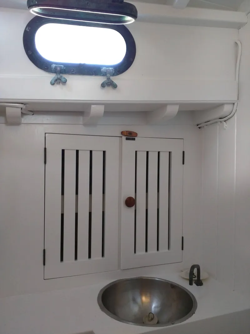Slide: The Image of 1964 Concordia 41 Yawl interior with sink and cabinet under porthole. - 15