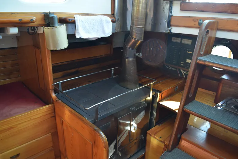 Slide: The Image of Interior of 1964 Concordia 41 Yawl, featuring a classic wooden stove and cabinetry. - 21