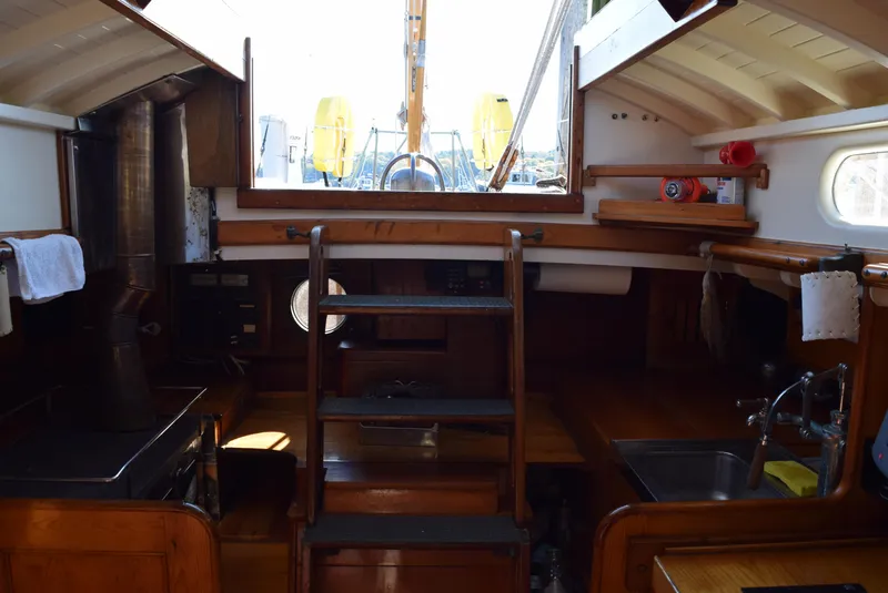 Slide: The Image of Interior of 1964 Concordia 41 Yawl sailboat, featuring wooden cabinetry and compact kitchen area. - 7