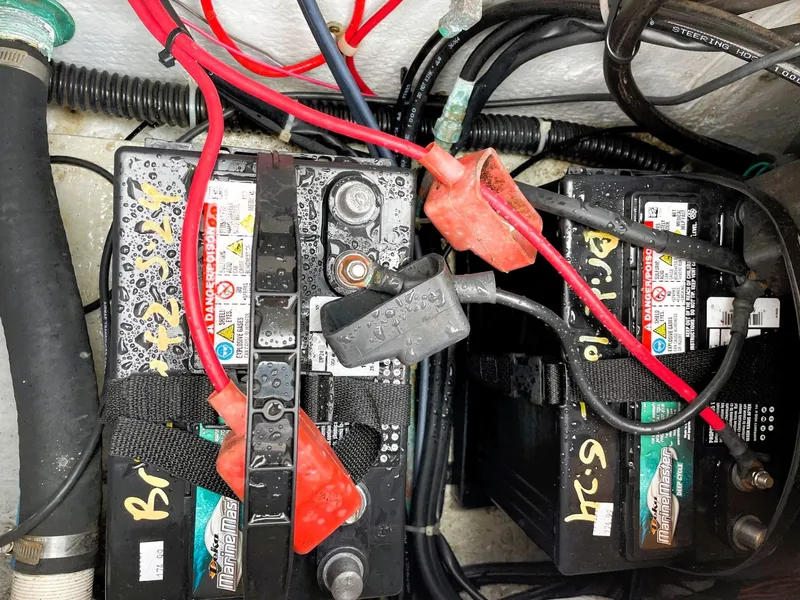 Slide: The Image of Boat batteries with red and black cables in a 2001 Grady-White Adventure 208. - 14