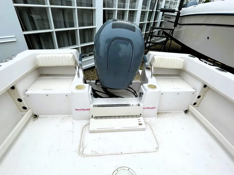 Slide: The Image of 2001 Grady-White Adventure 208 boat interior with motor, white seating, and storage compartments. - 7