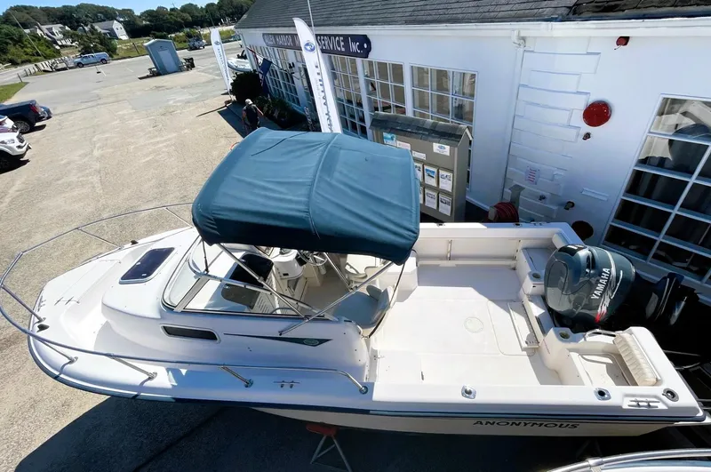 Slide: The Image of 2001 Grady-White Adventure 208 boat with canopy, docked near a building. - 8