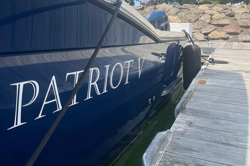 Slide: The Image of 2024 Scout 330 LXF boat named "Patriot V" docked at a marina. - 10