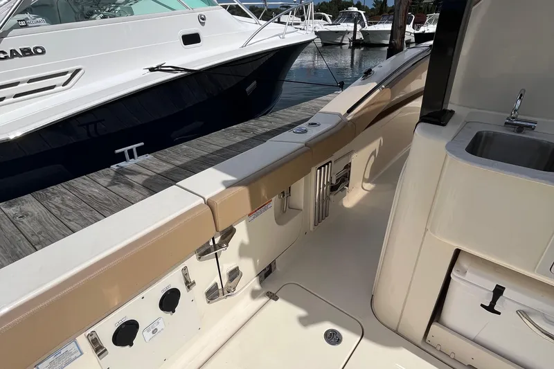 Slide: The Image of 2024 Scout 330 LXF boat interior with docked yachts in the background. - 15