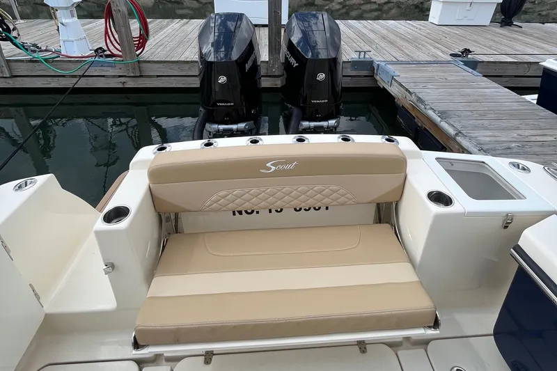 Slide: The Image of 2024 Scout 330 LXF boat with dual engines and beige seating at a dock. - 19