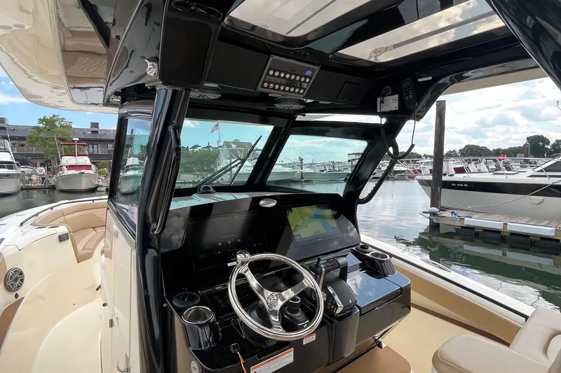 Slide: The Image of 2024 Scout 330 LXF boat cockpit with modern controls and marina view. - 22