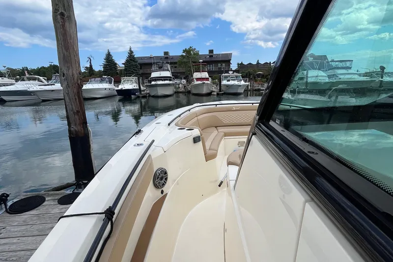 Slide: The Image of 2024 Scout 330 LXF boat docked in marina, surrounded by other boats. - 23