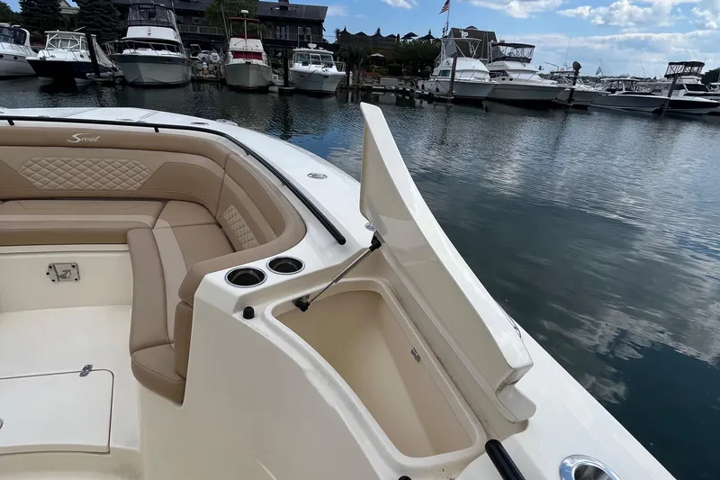 Slide: The Image of 2024 Scout 330 LXF boat interior with open storage compartment, docked at marina. - 24
