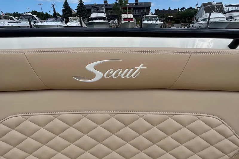 Slide: The Image of 2024 Scout 330 LXF boat interior with quilted leather seating at marina. - 26