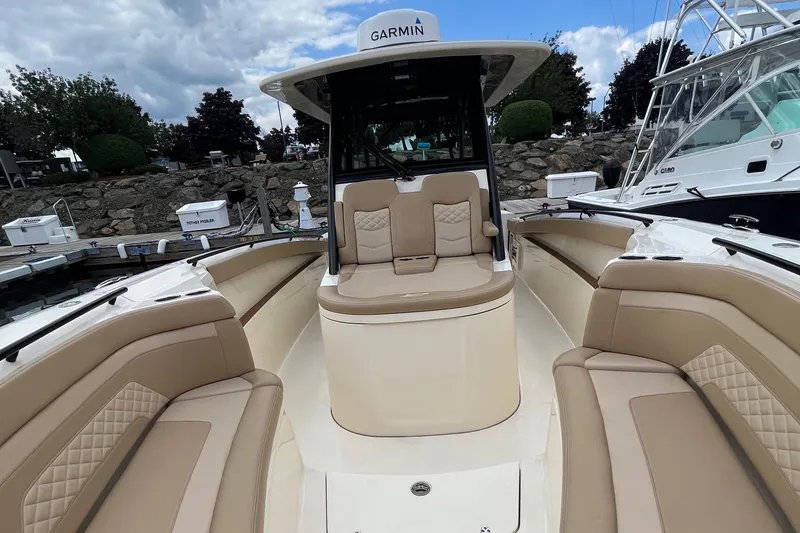 Slide: The Image of 2024 Scout 330 LXF boat with tan seating and Garmin equipment, docked at marina. - 28