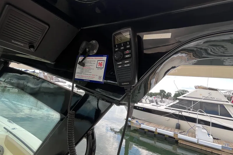 Slide: The Image of 2024 Scout 330 LXF boat interior with radio and marina view. - 33