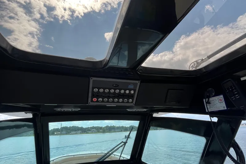 Slide: The Image of 2024 Scout 330 LXF boat interior with panoramic sunroof and control panel. - 39
