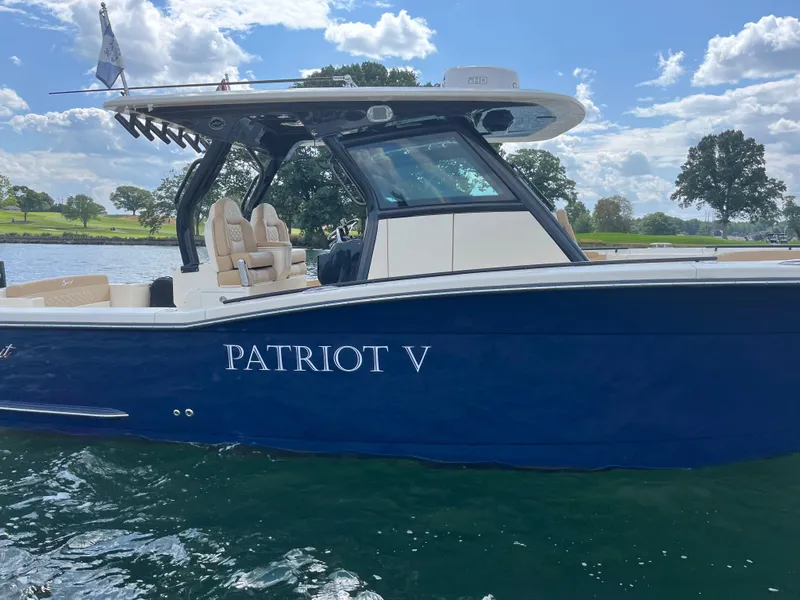 Slide: The Image of 2024 Scout 330 LXF boat named "Patriot V" on a sunny day. - 7