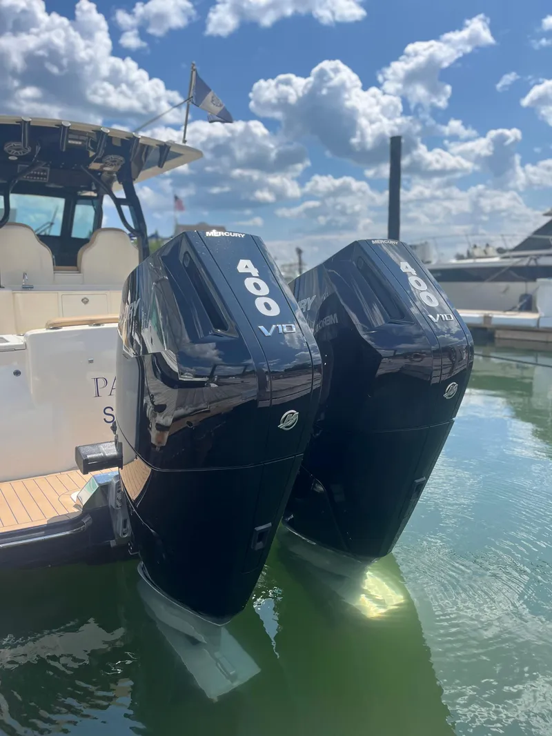Slide: The Image of 2024 Scout 330 LXF boat with twin 400 V10 engines docked in marina. - 8