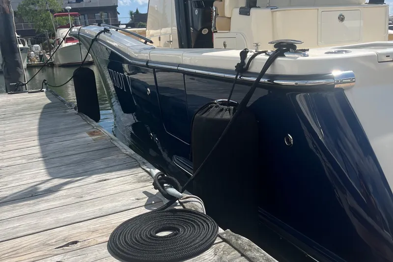 Slide: The Image of 2024 Scout 330 LXF boat docked, showcasing sleek design and modern features. - 9